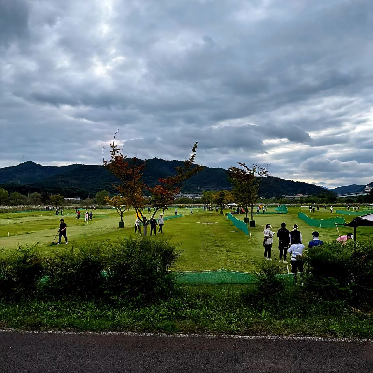 Park Golf (파크골프) players smiling, waving, and shouting 화이팅 (you can do it)